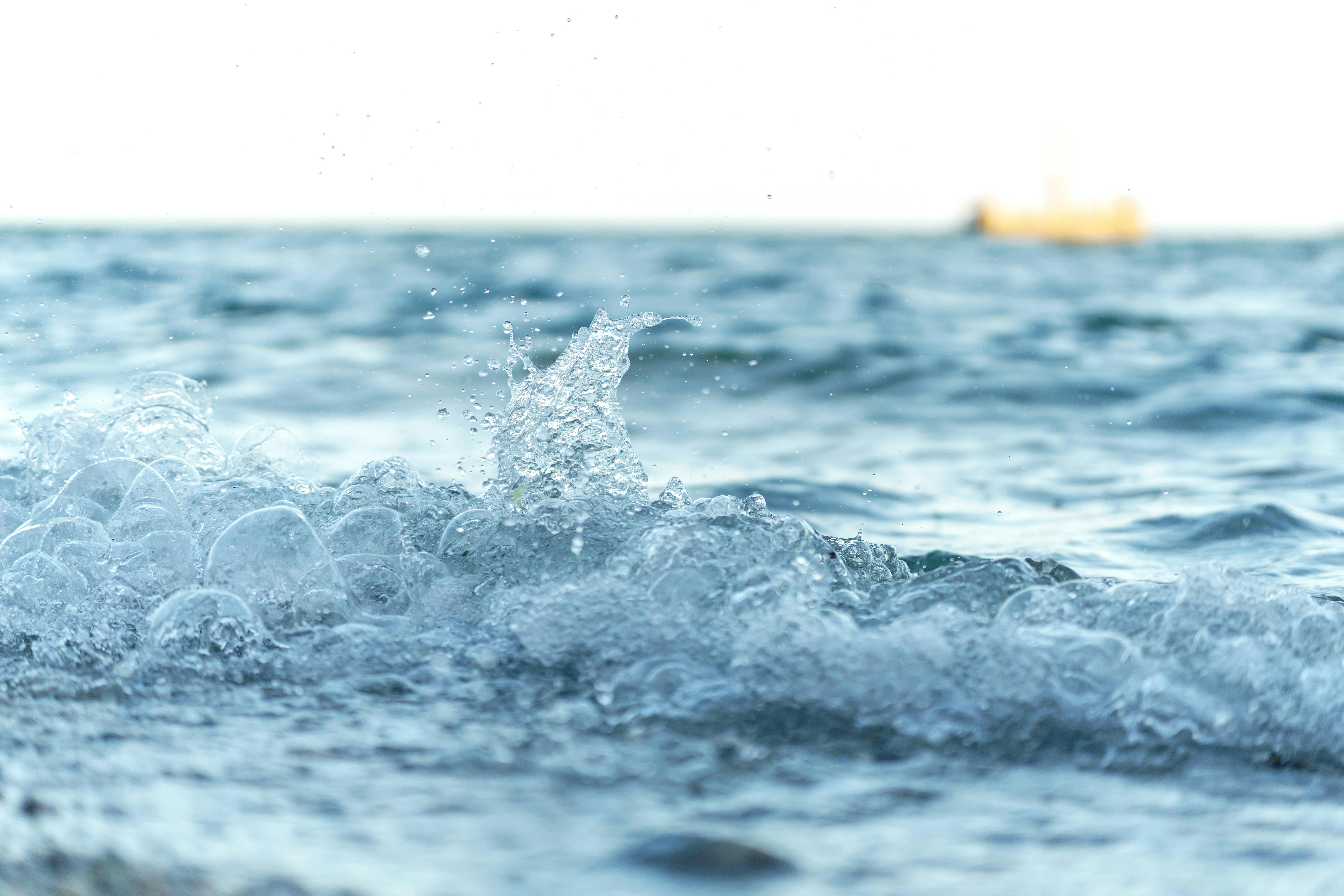 免費 平靜廣闊的海平線上，拍打著浪花的迷人特寫。 圖庫相片