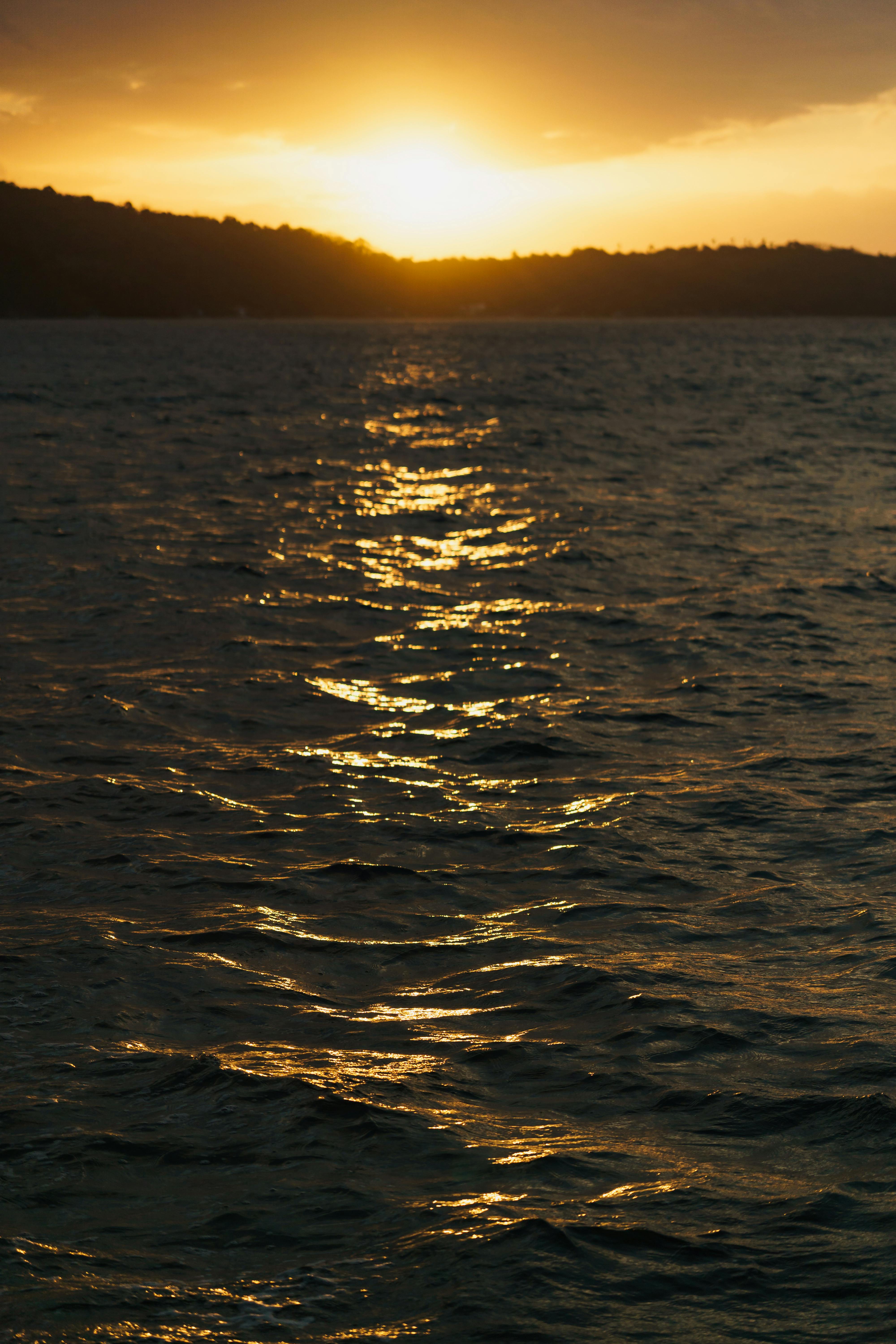 免費 金色的夕陽倒映在海面上，營造出寧靜祥和的氛圍。 圖庫相片