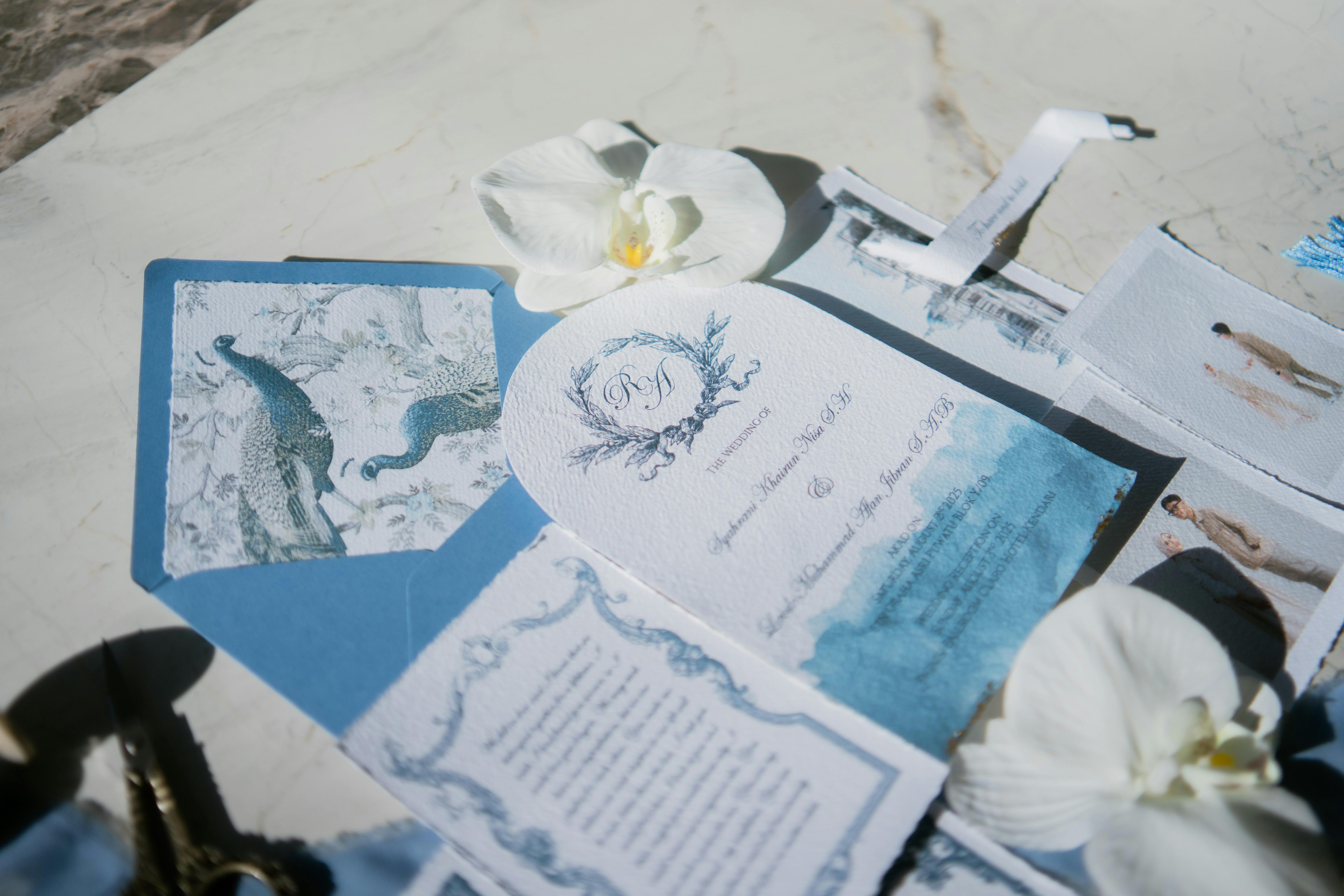 Безкоштовне Елегантний набір весільних запрошень із зображенням павича та білих орхідей на мармуровому фоні. стокове фото