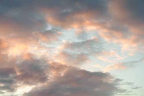 Free A tranquil view of a sunset sky filled with soft, pastel-colored clouds. Stock Photo