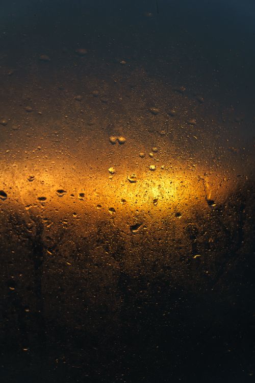 Free Dramatic view of a sunset through a rain-speckled window, evoking a warm and moody atmosphere. Stock Photo
