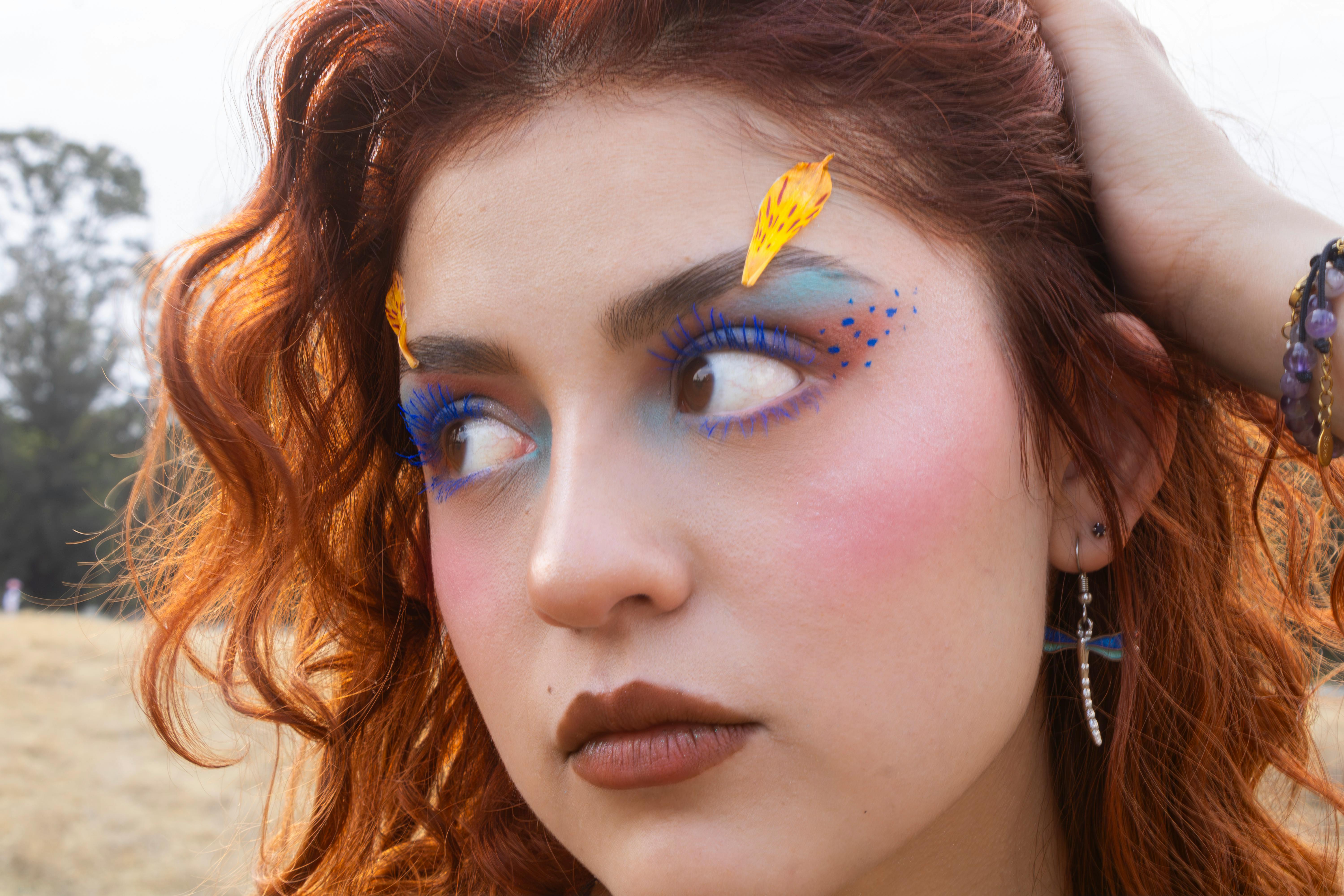免費 一張戶外拍攝的特寫肖像，照片中的女子化著精緻的妝容，一頭紅髮。 圖庫相片