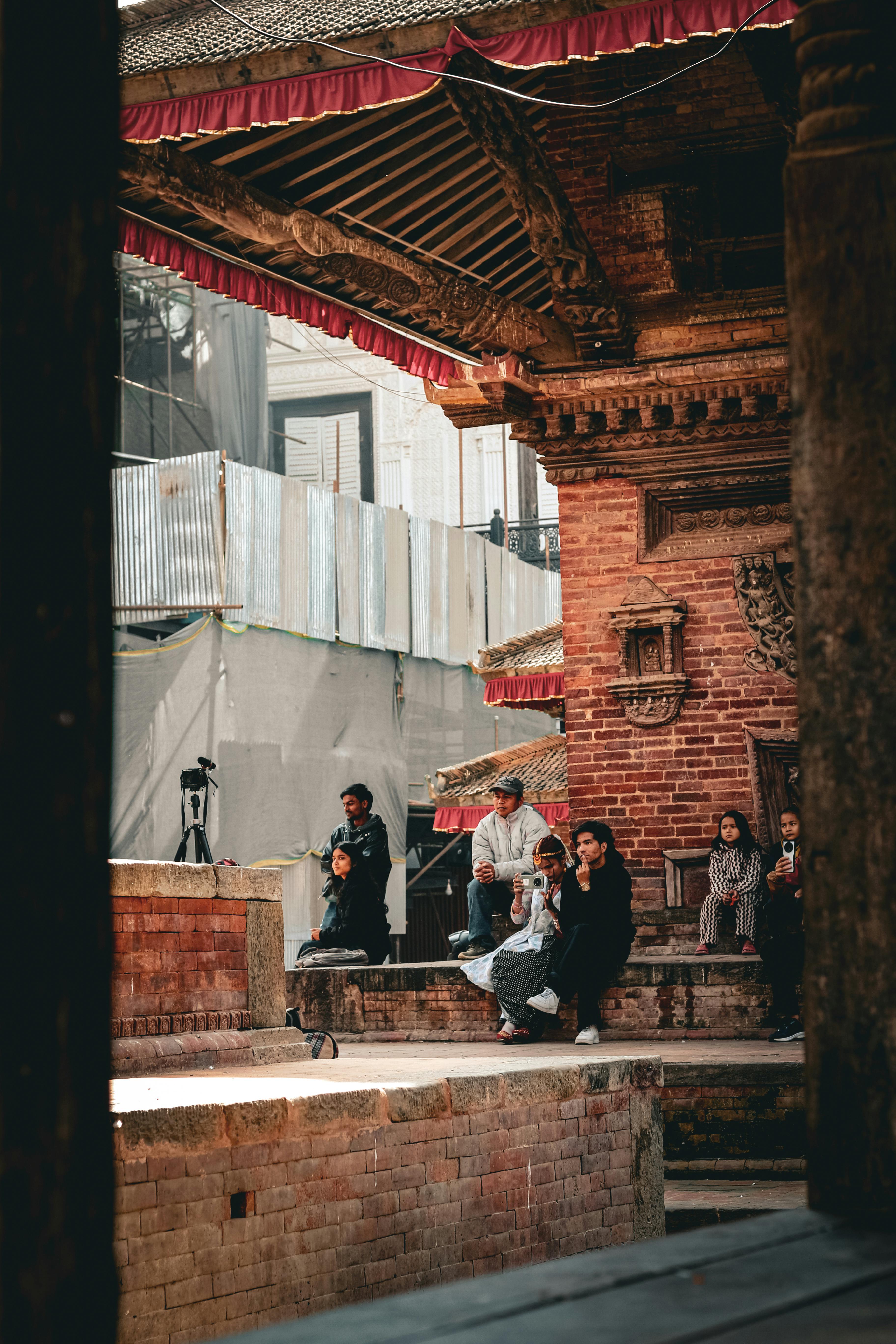 Безкоштовне Відвідувачі відпочивають біля стародавньої архітектури на площі Патан Дурбар, Катманду, Непал. стокове фото