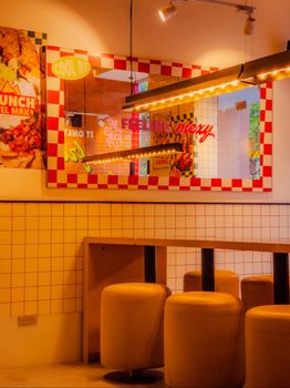 Vibrant retro diner interior featuring neon signs and checker tile decor, perfect for nostalgic settings.
