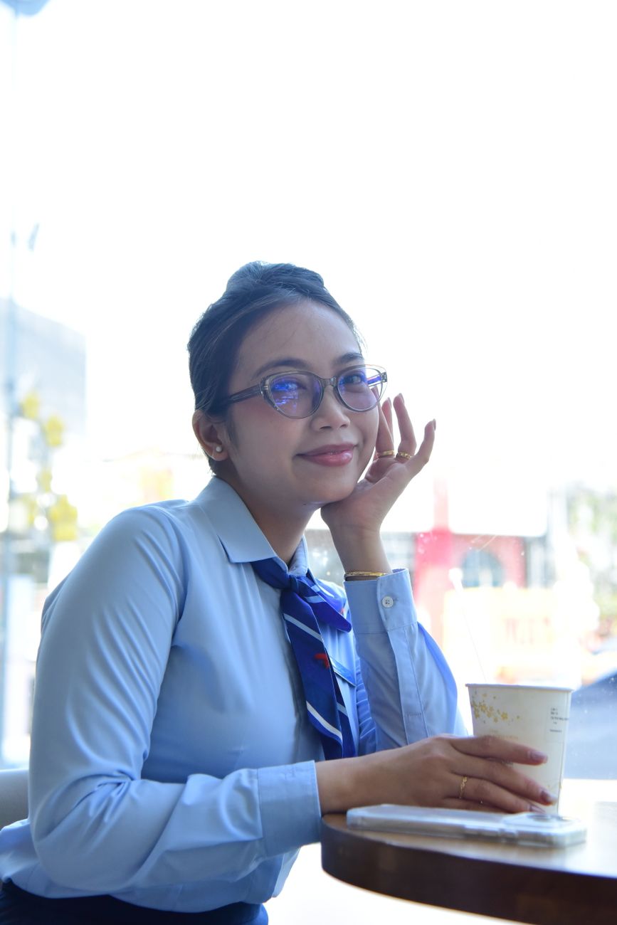 Confident woman in formal attire enjoying a coffee break at a cafe. Perfect for lifestyle and business themes.