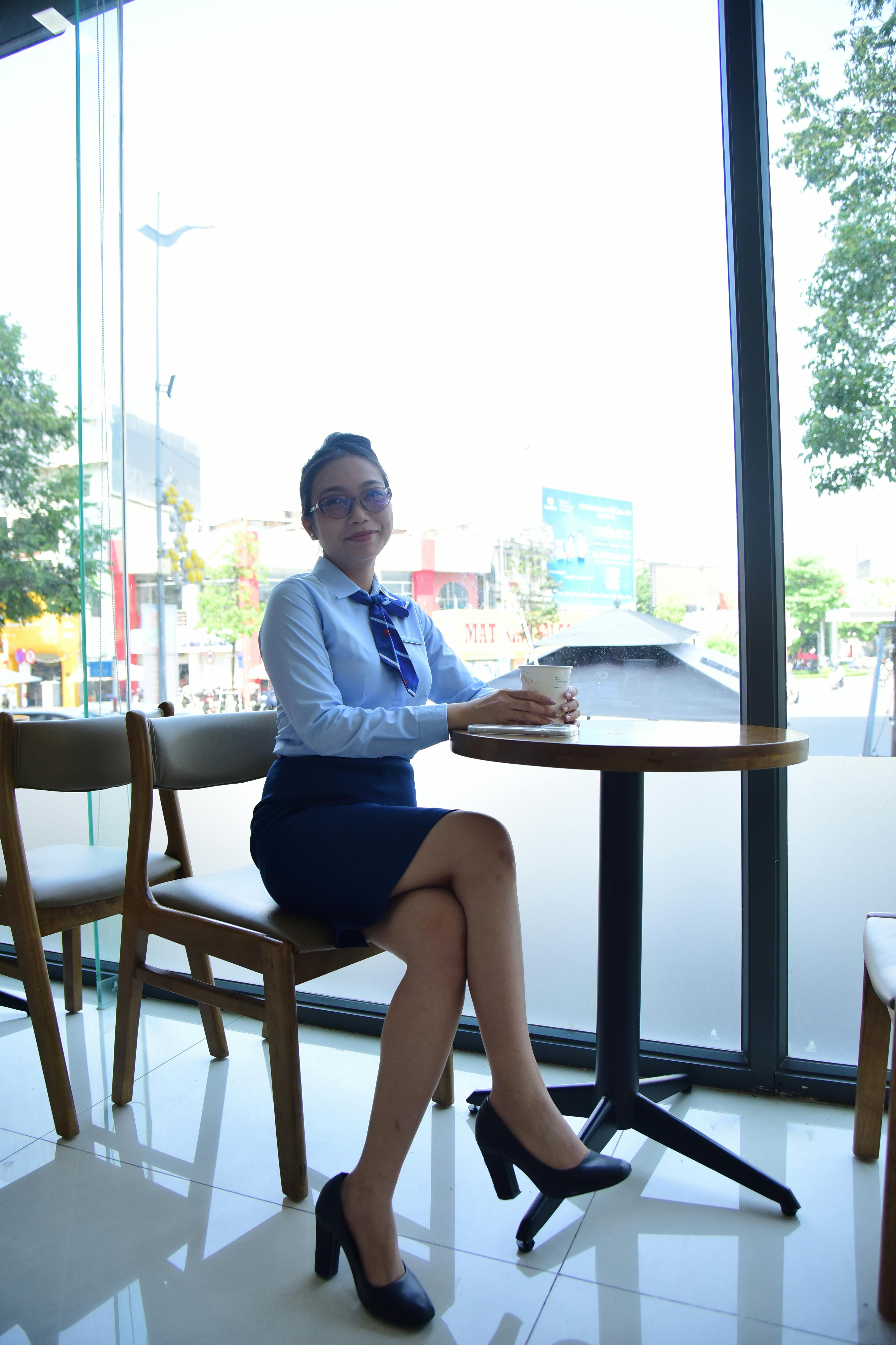 免費 一位女商人坐在靠窗的咖啡桌旁，享受著咖啡休息時間。 圖庫相片