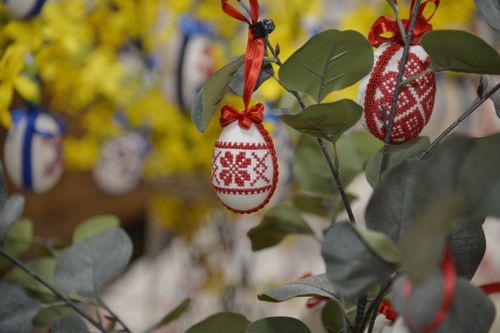 Free Vibrant Easter eggs with cross-stitch embroidery hanging on a decorative tree in spring. Stock Photo