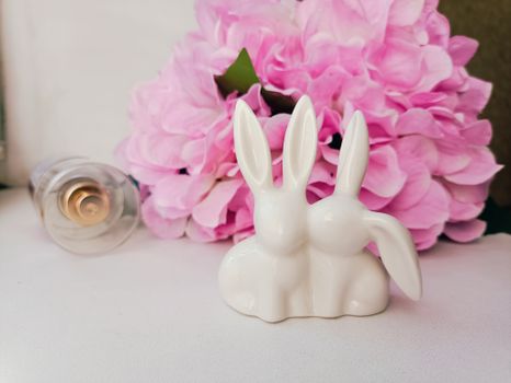 Charming ceramic bunny figurines displayed with vibrant pink hydrangeas, perfect for home decor inspiration.