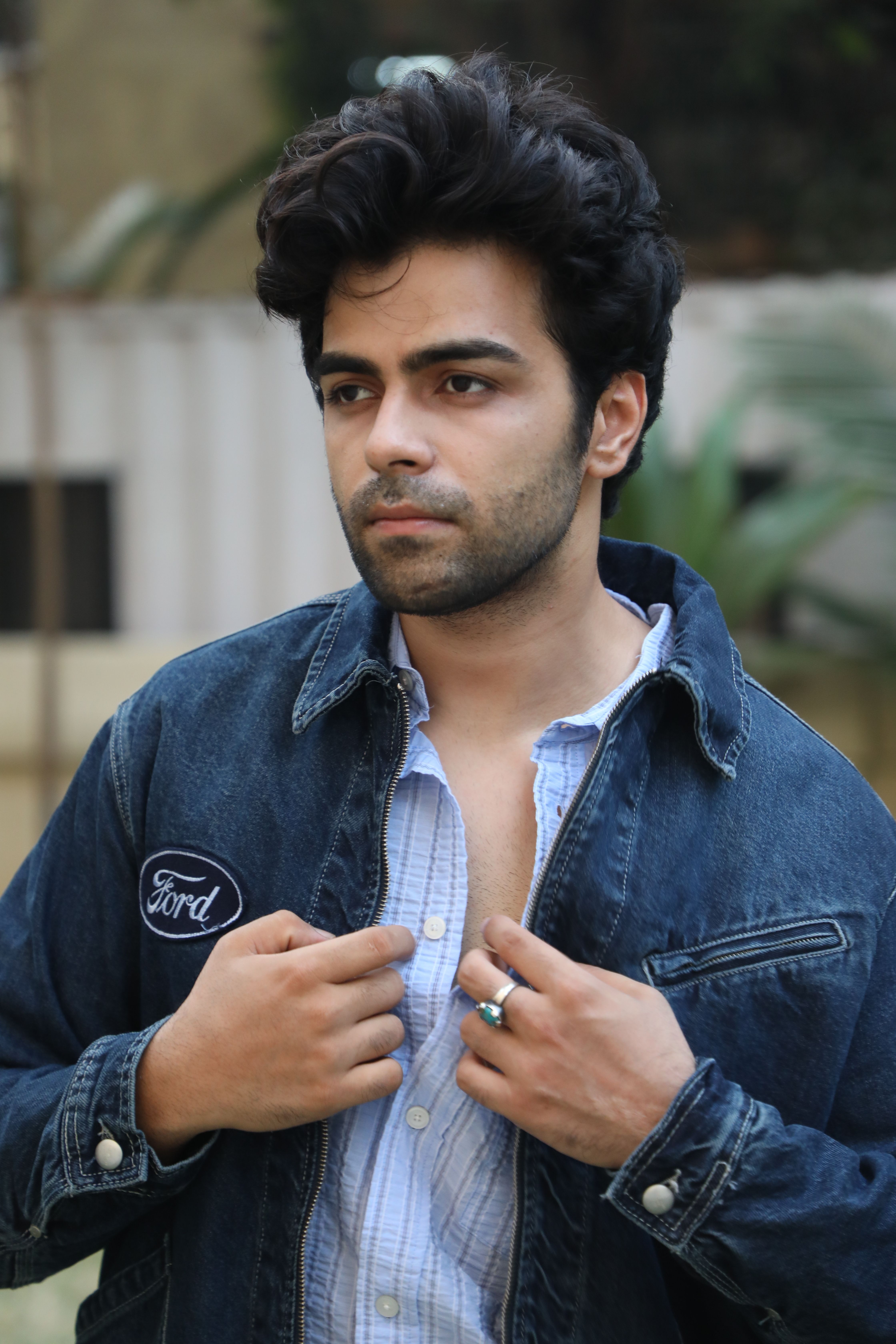 Portrait of a man wearing a denim jacket, outdoors.