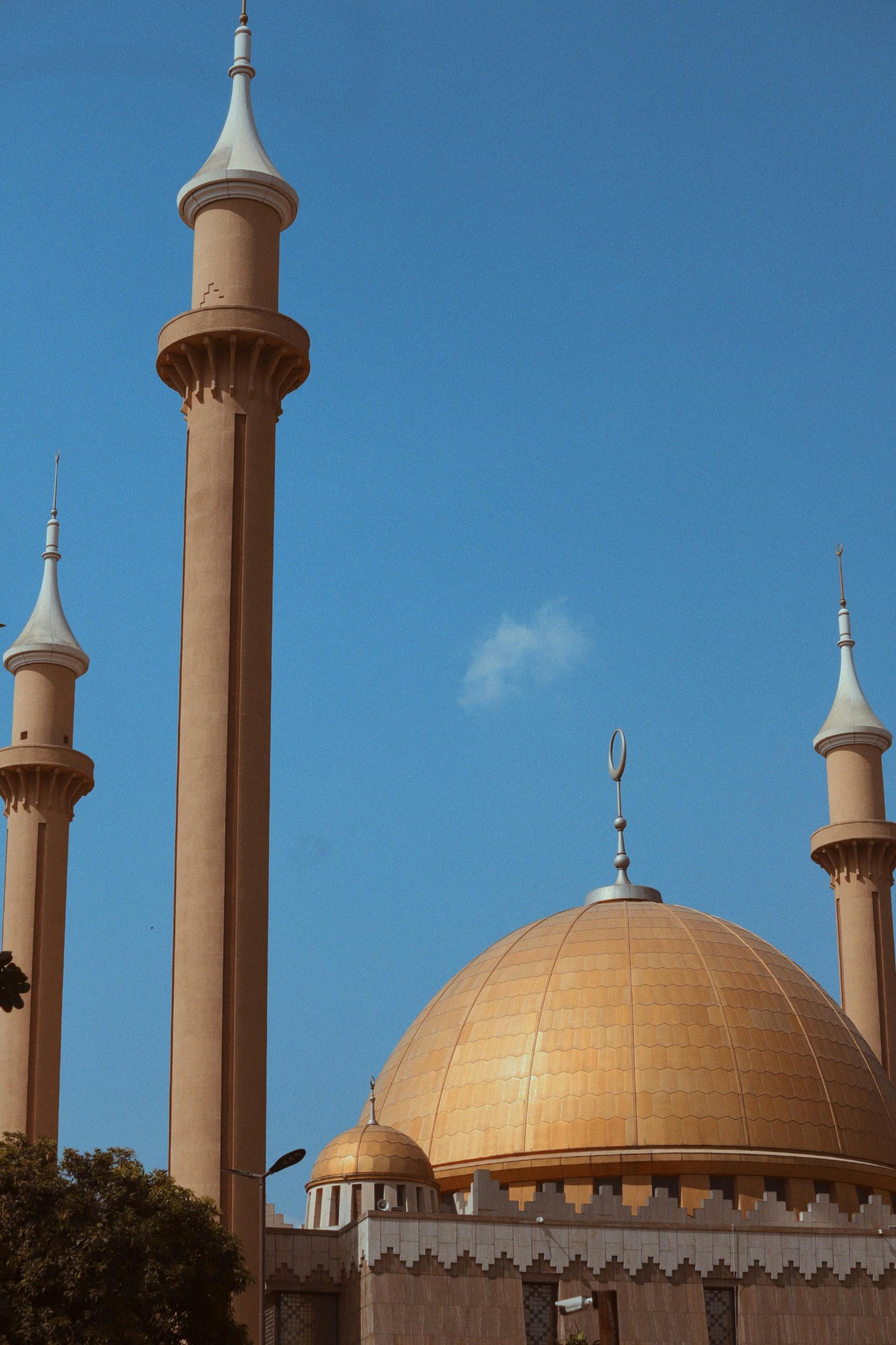 Zadarmo Jasná modrá obloha zvýrazňuje majestátnu zlatú kupolu a minarety Národnej mešity v Abuje. Fotka z fotobanky