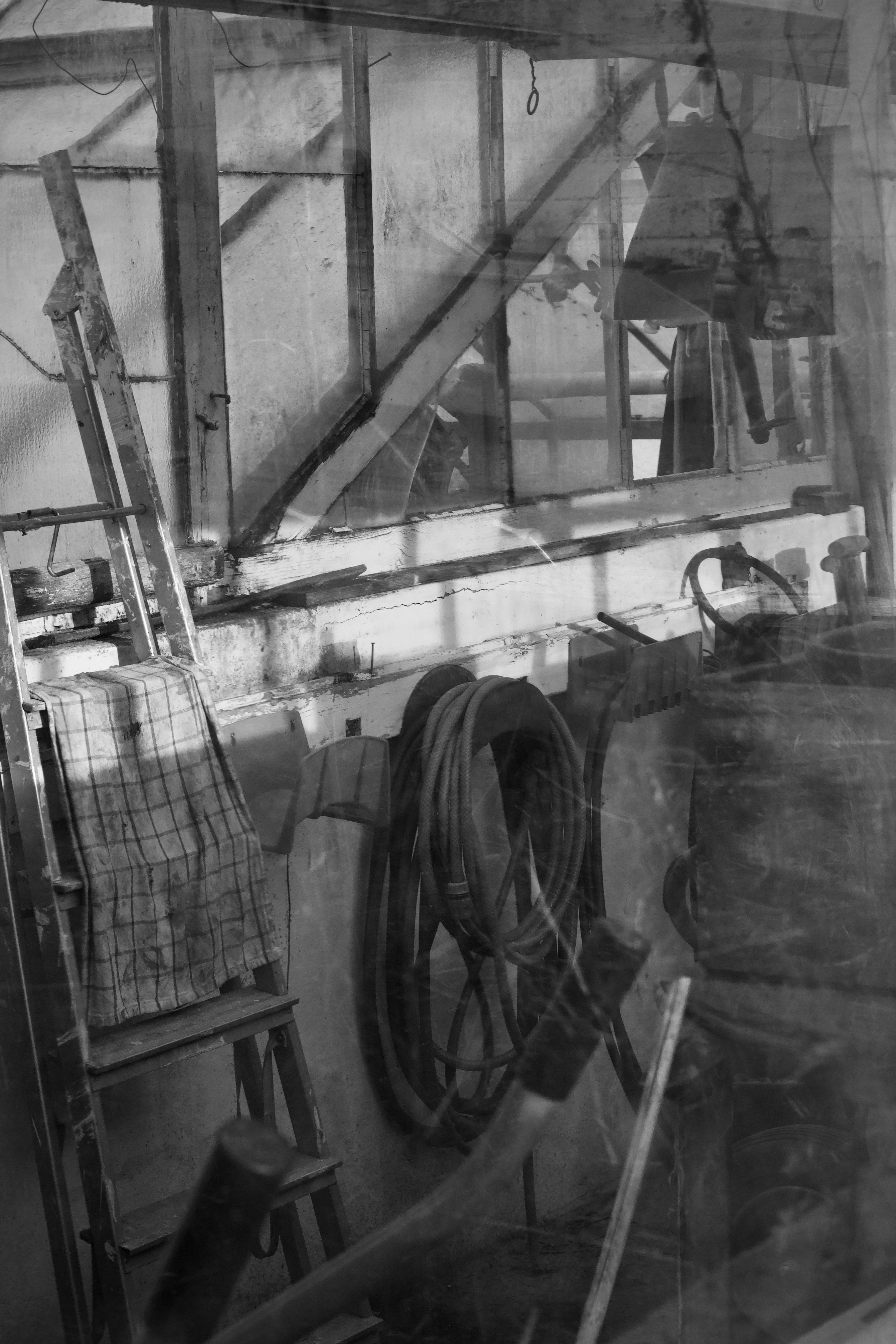 ingyenes Egy fekete-fehér fotó egy régi műhelybelsőről szerszámokkal és gépekkel. Stockfotó