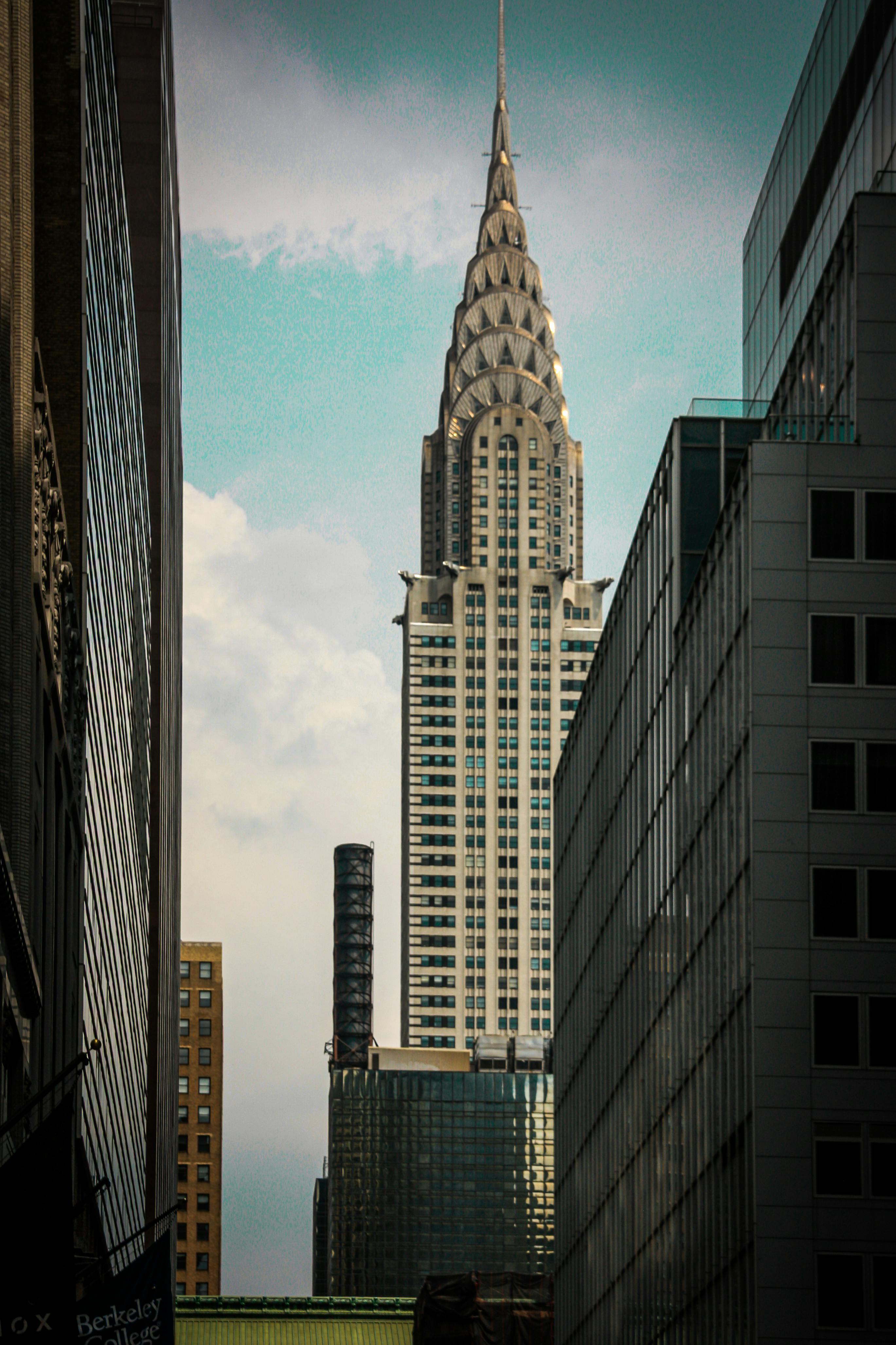 免费 标志性的克莱斯勒大厦坐落在纽约市摩天大楼群中，展现了装饰艺术风格的建筑和城市天际线。 素材图片