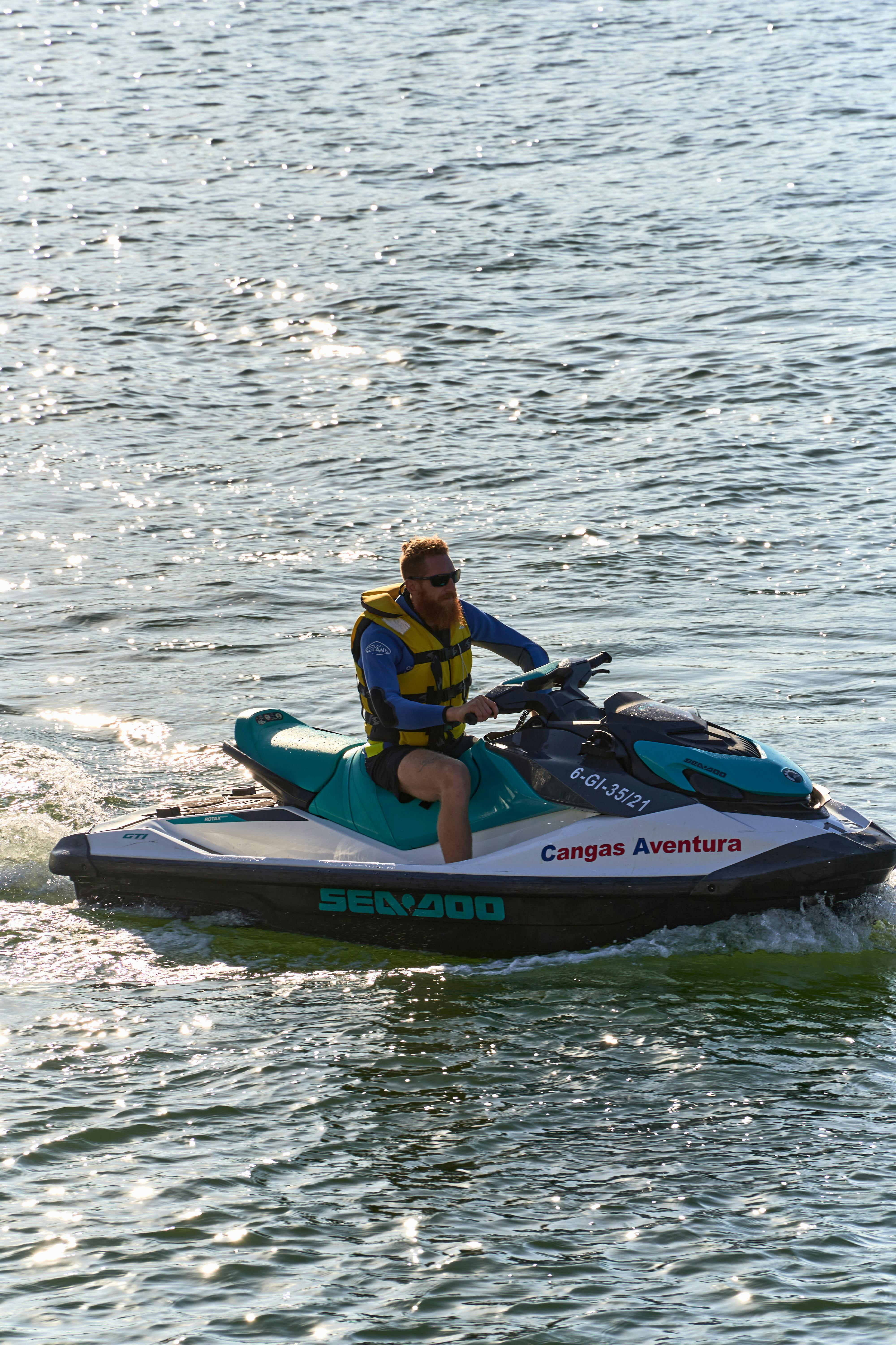 免费 在西班牙利亚内斯，有人骑着水上摩托艇享受夏日冒险。 素材图片