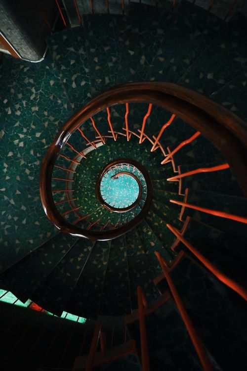 Free Elegant spiral staircase with rich colors and swirling design. Stock Photo