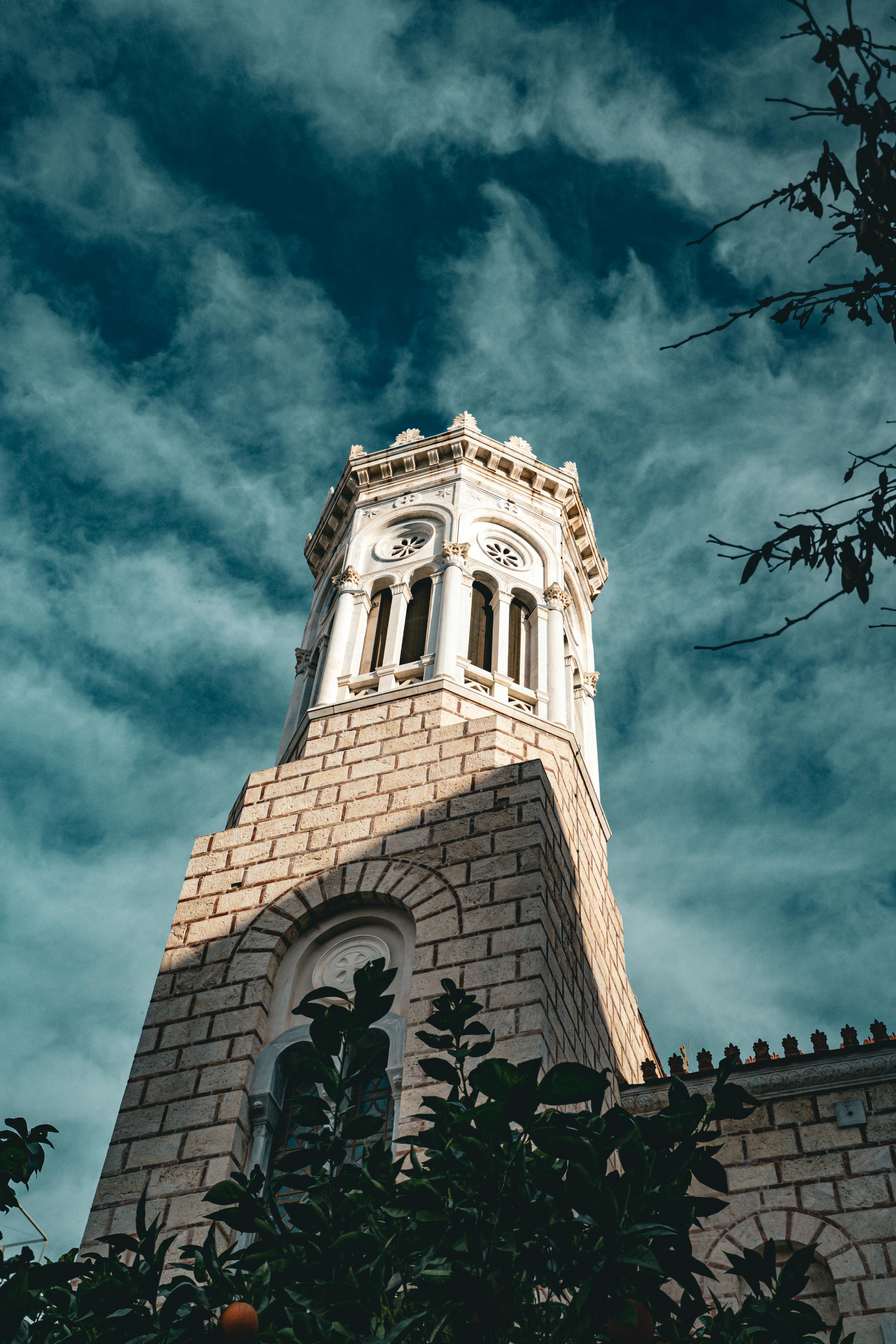 ingyenes Egy történelmi kőóratorony részletes felvétele a drámai felhős égbolt hátterében, felülnézetből. Stockfotó