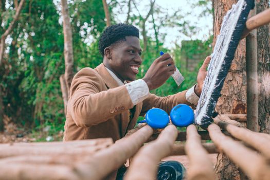 Smiling artist painting a canvas outside in vibrant Accra, showcasing creativity and culture.