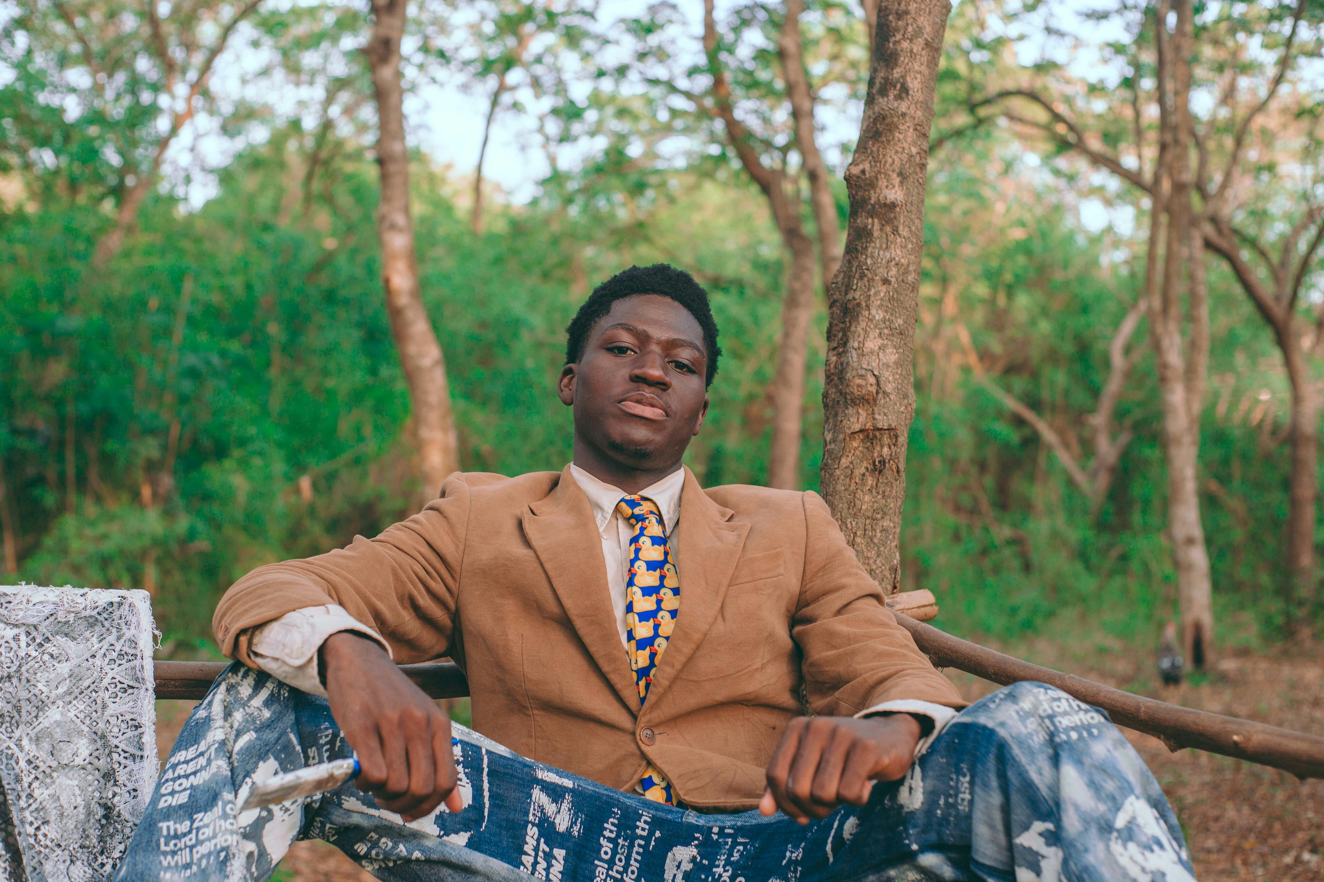 Zadarmo Módny muž v obleku sebavedomo pózuje v pokojnom lesnom pozadí v Akkre v Ghane. Fotka z fotobanky