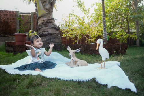 Free Cute child enjoying time outdoors with animal statues on a sunny day. Stock Photo