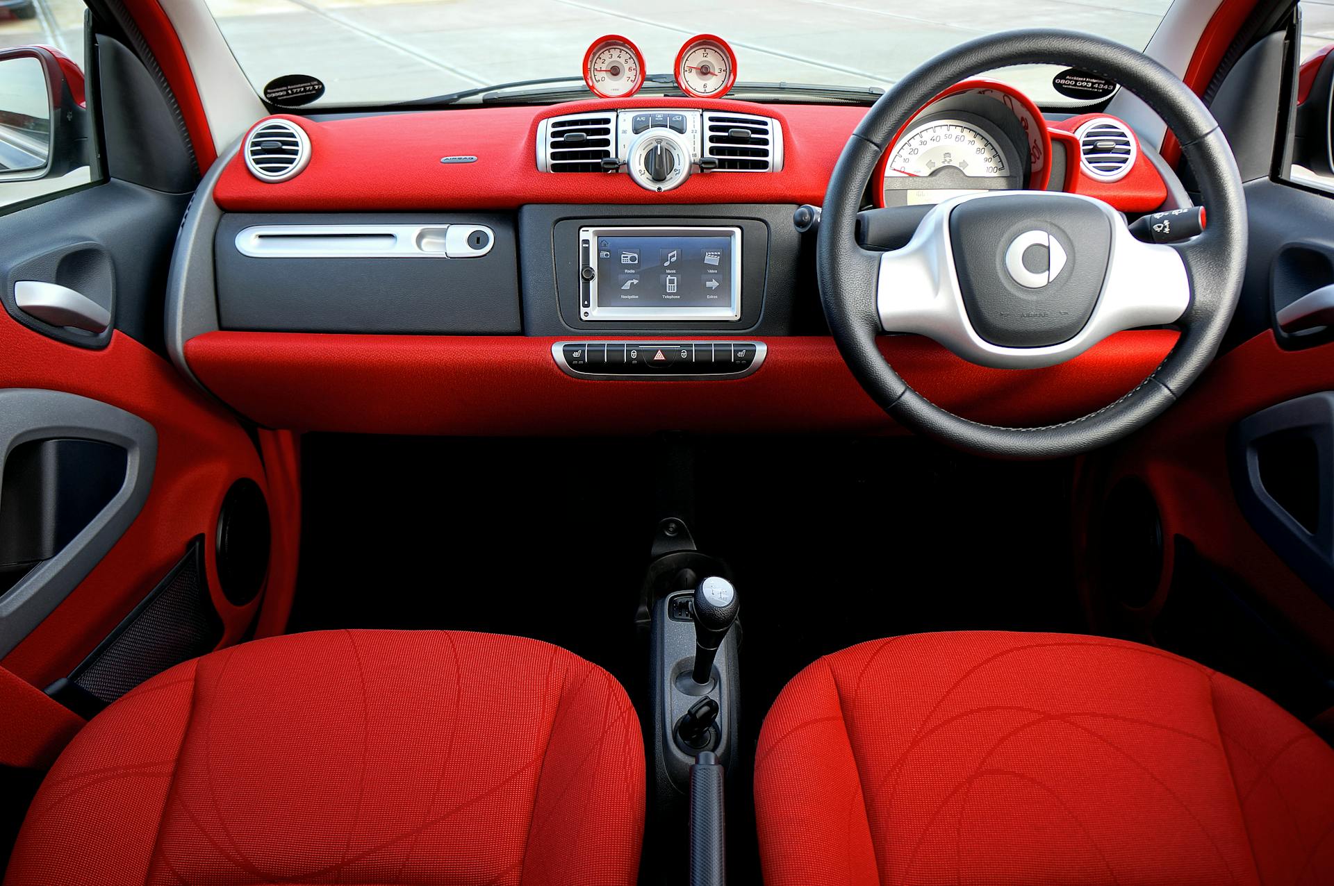 Explore the sleek design and vibrant red tones in this modern car interior shot.