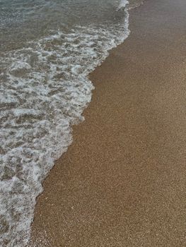 Peaceful waves on Glyfada Beach's sandy shore in Greece, perfect for travel inspiration.