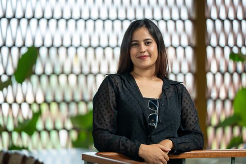 Free Smiling woman in a casual outfit poses confidently indoors. Stock Photo
