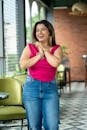 Joyful woman in pink top and jeans in cafe