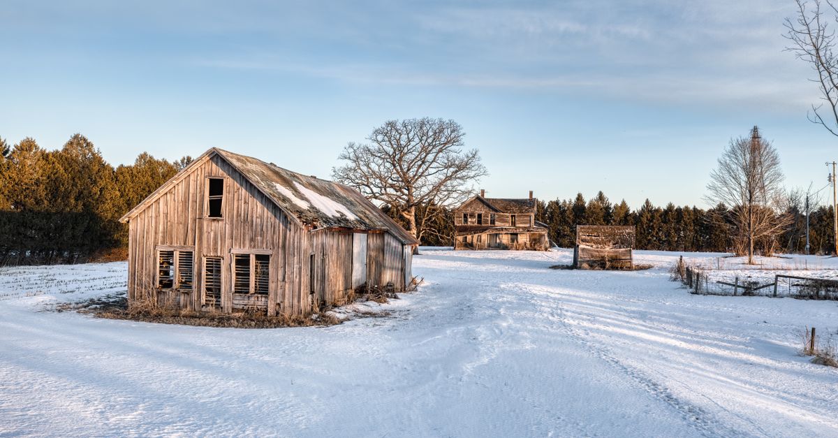 A snowy, abandoned farmhouse and barn in West Albany, Minnesota, USA