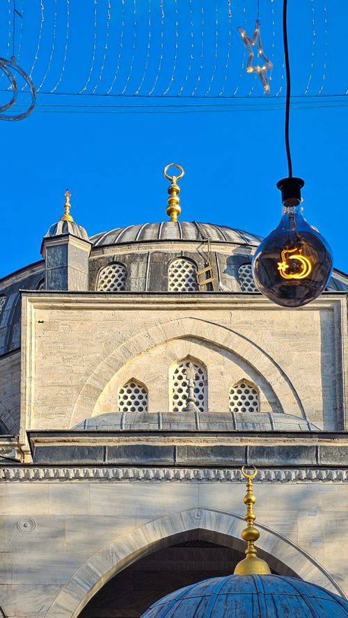 Free Close-up of an İstanbul mosque exterior with hanging bulb against a clear blue sky. Stock Photo