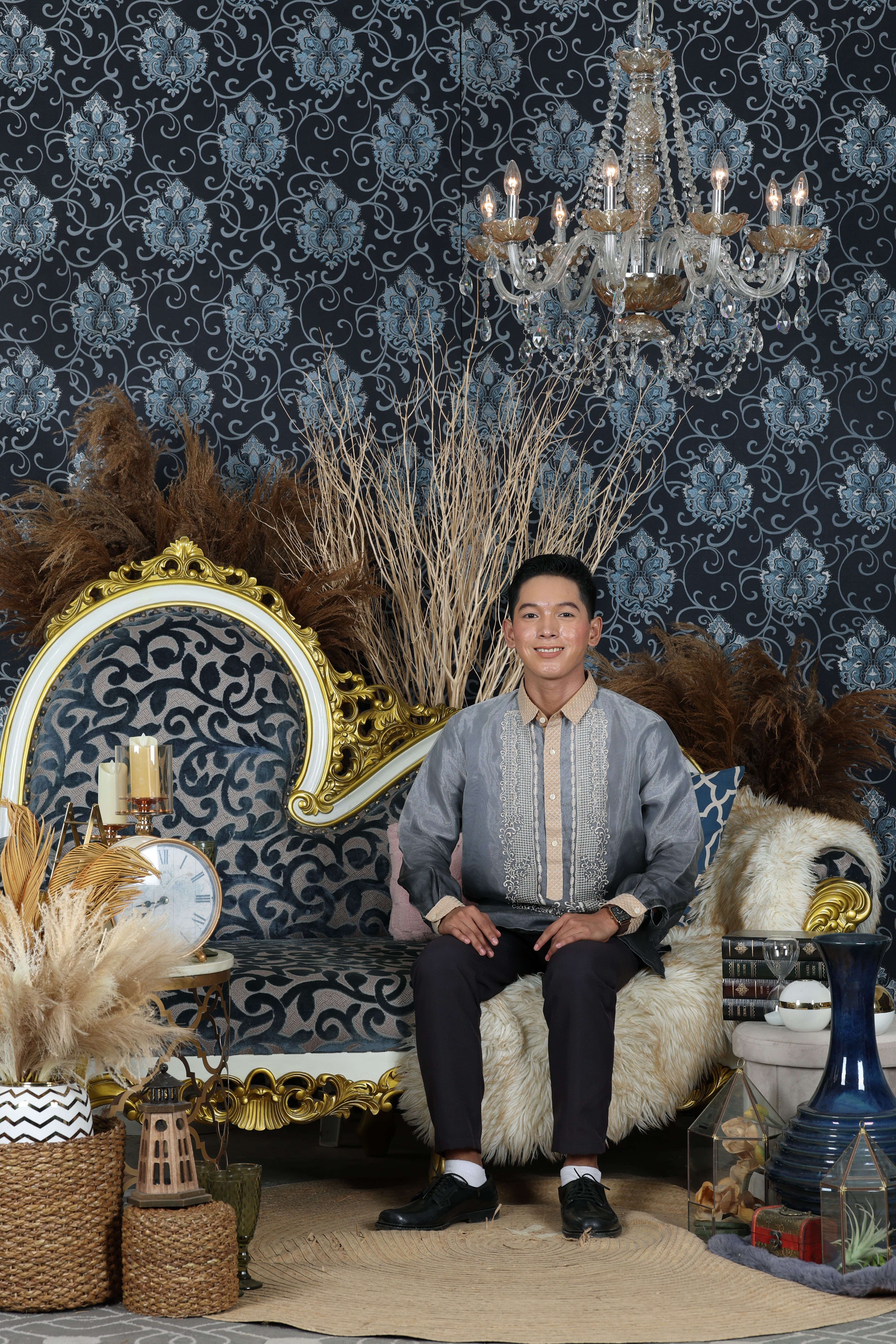 Stylish portrait of a man in a luxurious living room with vintage decor and ornate furniture.