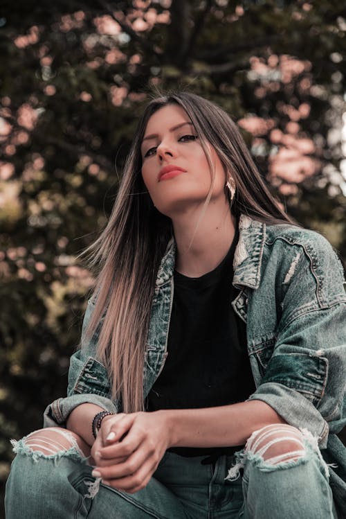 Photo of Woman in Blue Denim Jacket and Jeans Posing