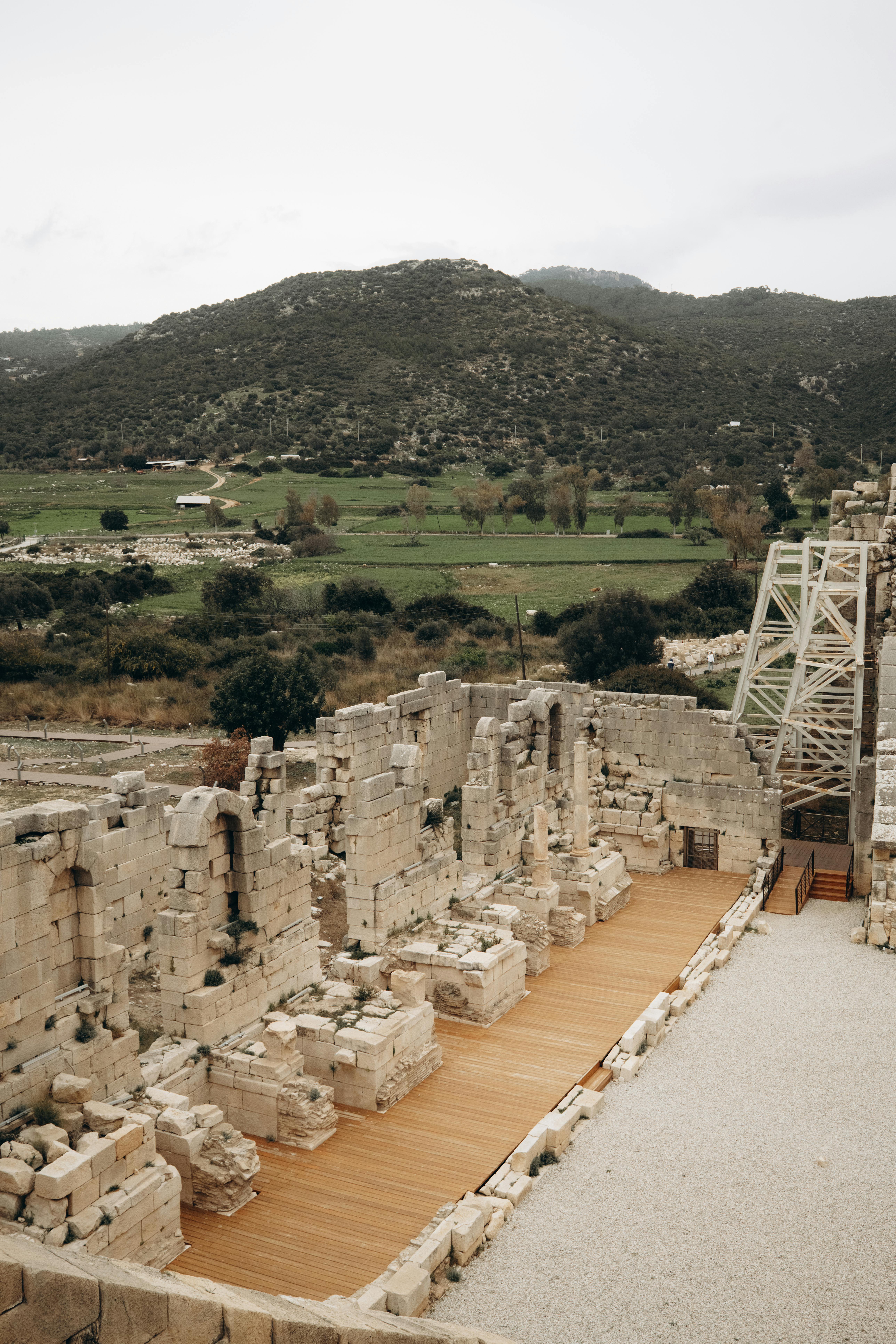 무료 울창한 풍경과 산으로 둘러싸인 고대 원형 경기장을 탐험하며 역사와 자연을 만끽해 보세요. 스톡 사진