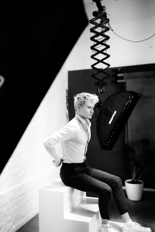 Free Young man posing in a professional studio with lighting equipment, black and white. Stock Photo