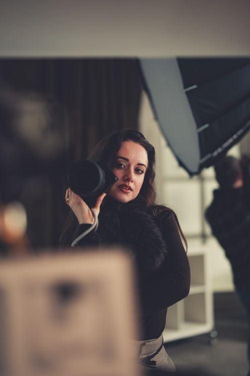 Free A woman photographer with camera and softbox in a studio setting. Perfect for photography and fashion themes. Stock Photo