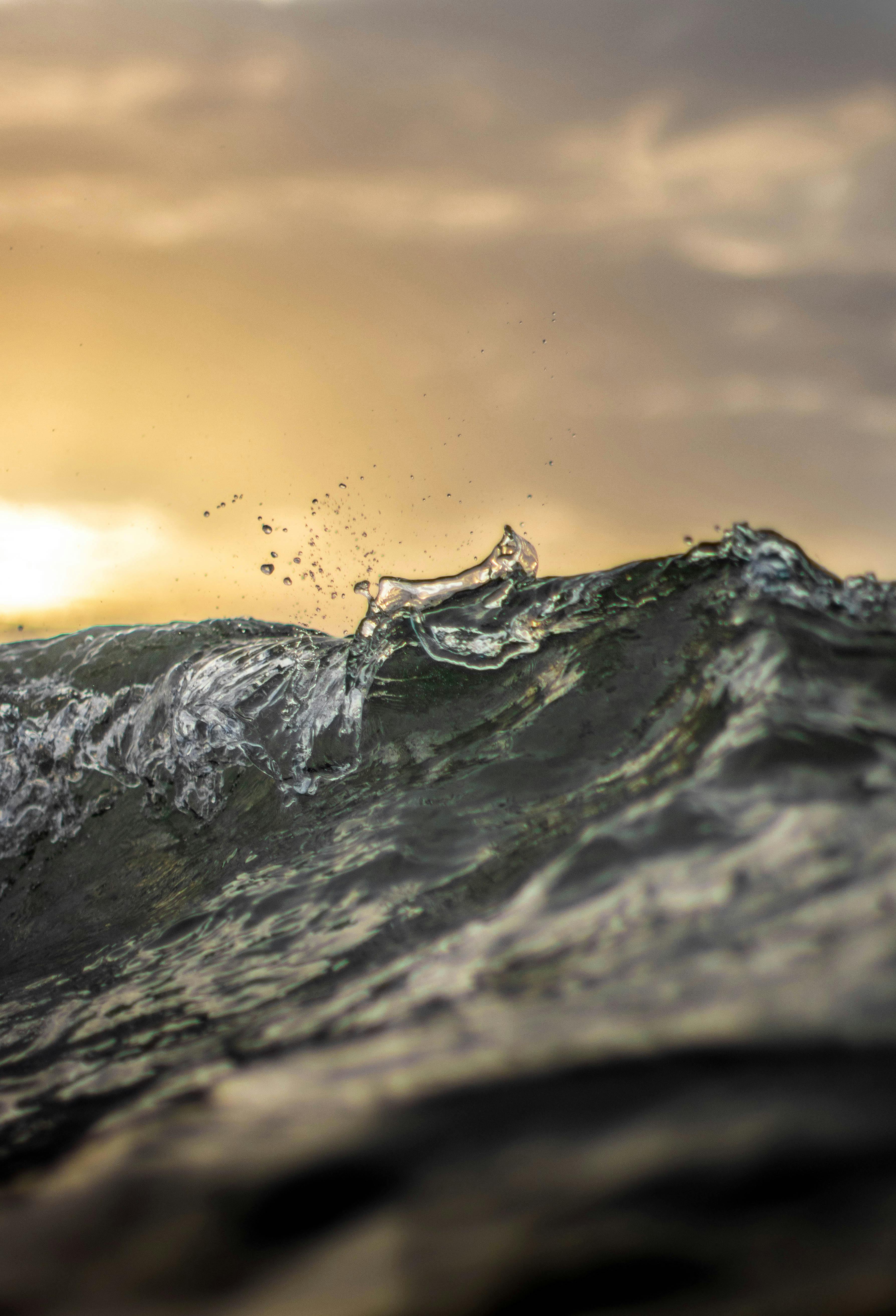 ฟรี ภาพคลื่นทะเลอันงดงามที่ถ่ายได้ยามพระอาทิตย์ตกดิน เผยให้เห็นถึงพลังอันยิ่งใหญ่ของธรรมชาติ คลังภาพถ่าย