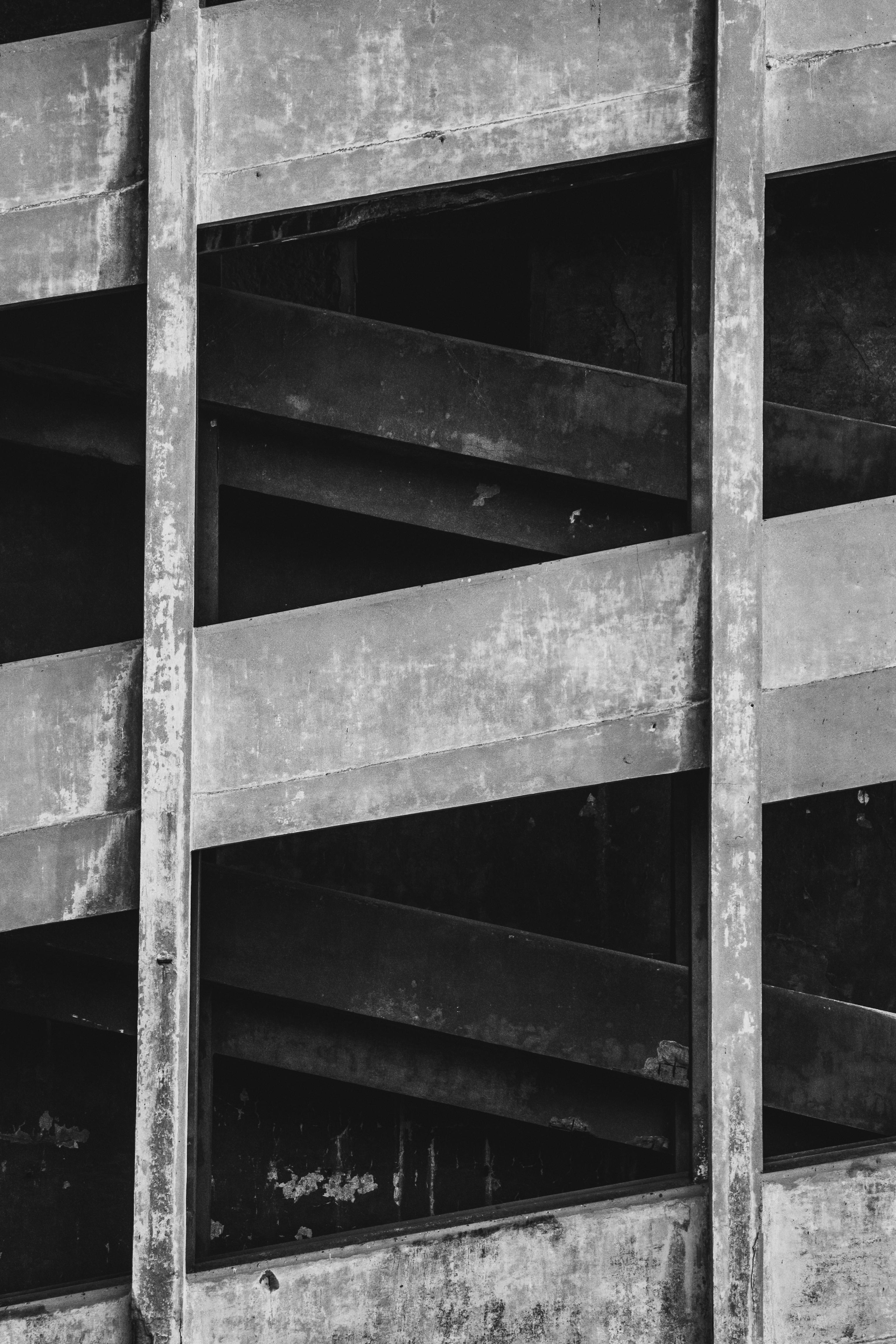 ingyenes Lenyűgöző fekete-fehér fotó, amely egy betonépület homlokzatának absztrakt képét mutatja be. Stockfotó