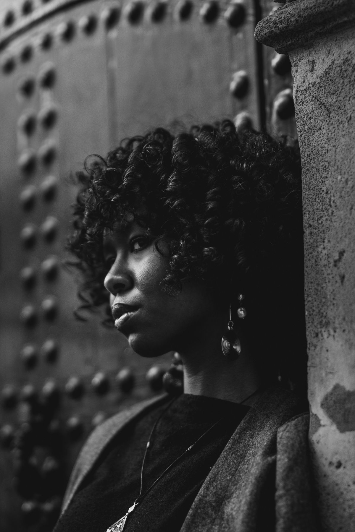 Woman with curly hair against a textured wall