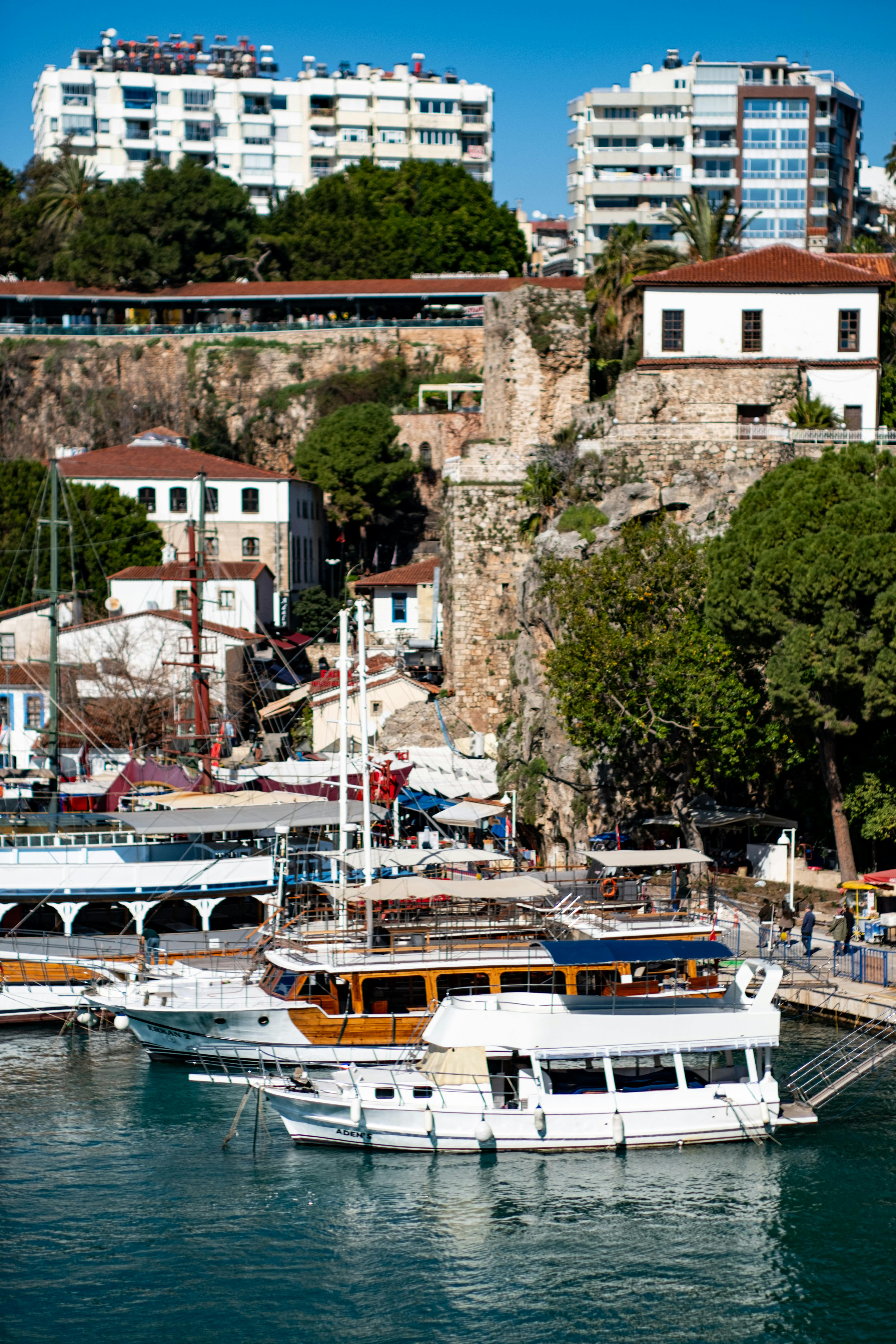 무료 터키 안탈리아의 유서 깊은 구항구의 아름다운 풍경입니다. 배들과 랜드마크 건축물들이 어우러져 있습니다. 스톡 사진