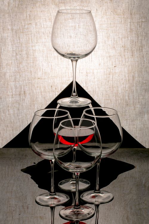 Free Artistic arrangement of wine glasses casting unique shadows and reflections in a studio setting. Stock Photo