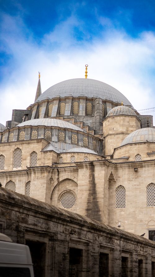 Free A stunning view of an Ottoman-era mosque with a classic dome and minarets under a bright blue sky. Stock Photo