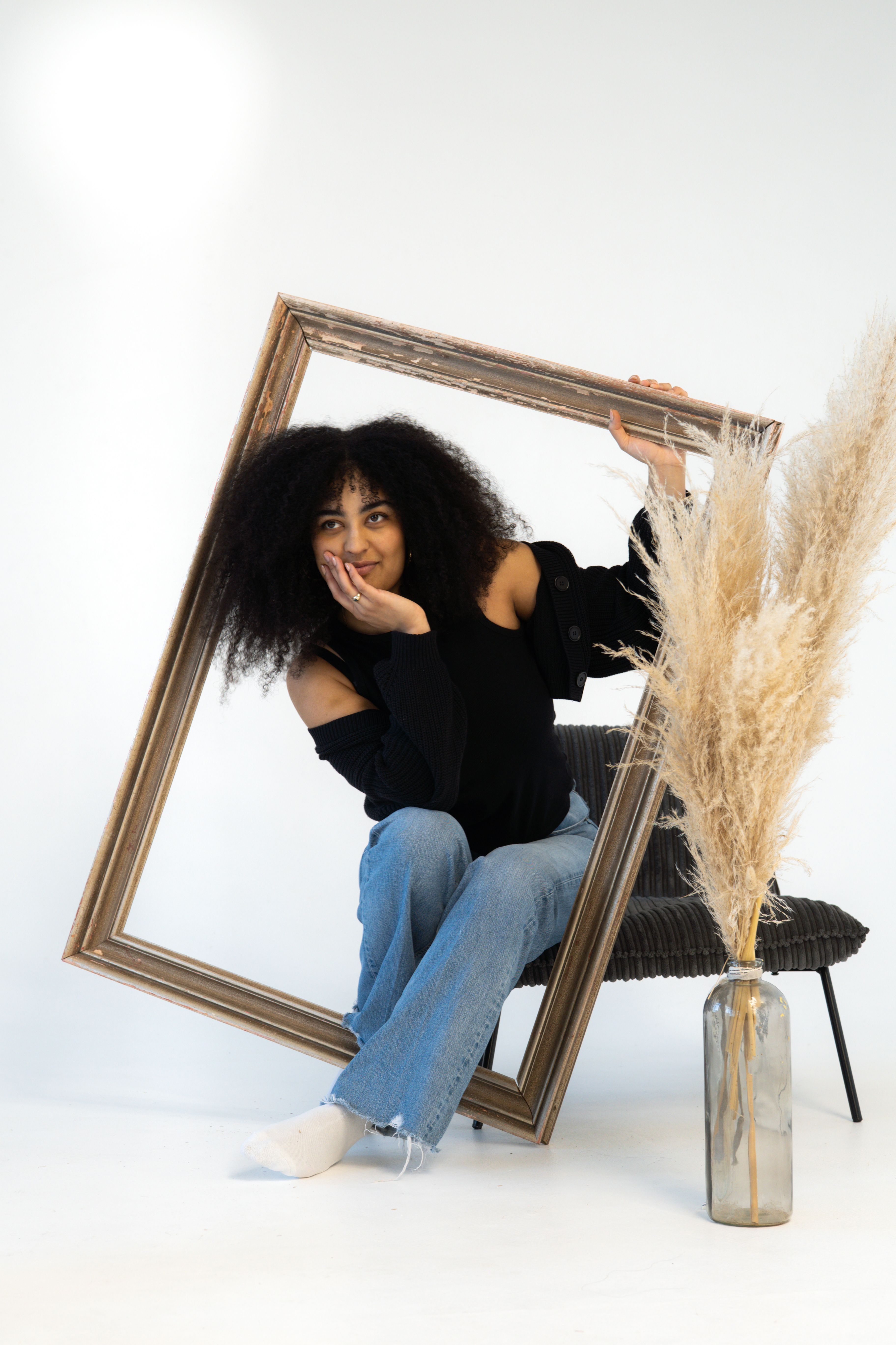 Gratuit Portret elegant al unei femei care ține o ramă goală, cu iarbă de pampas adăugând o notă boemă. Fotografie de stoc