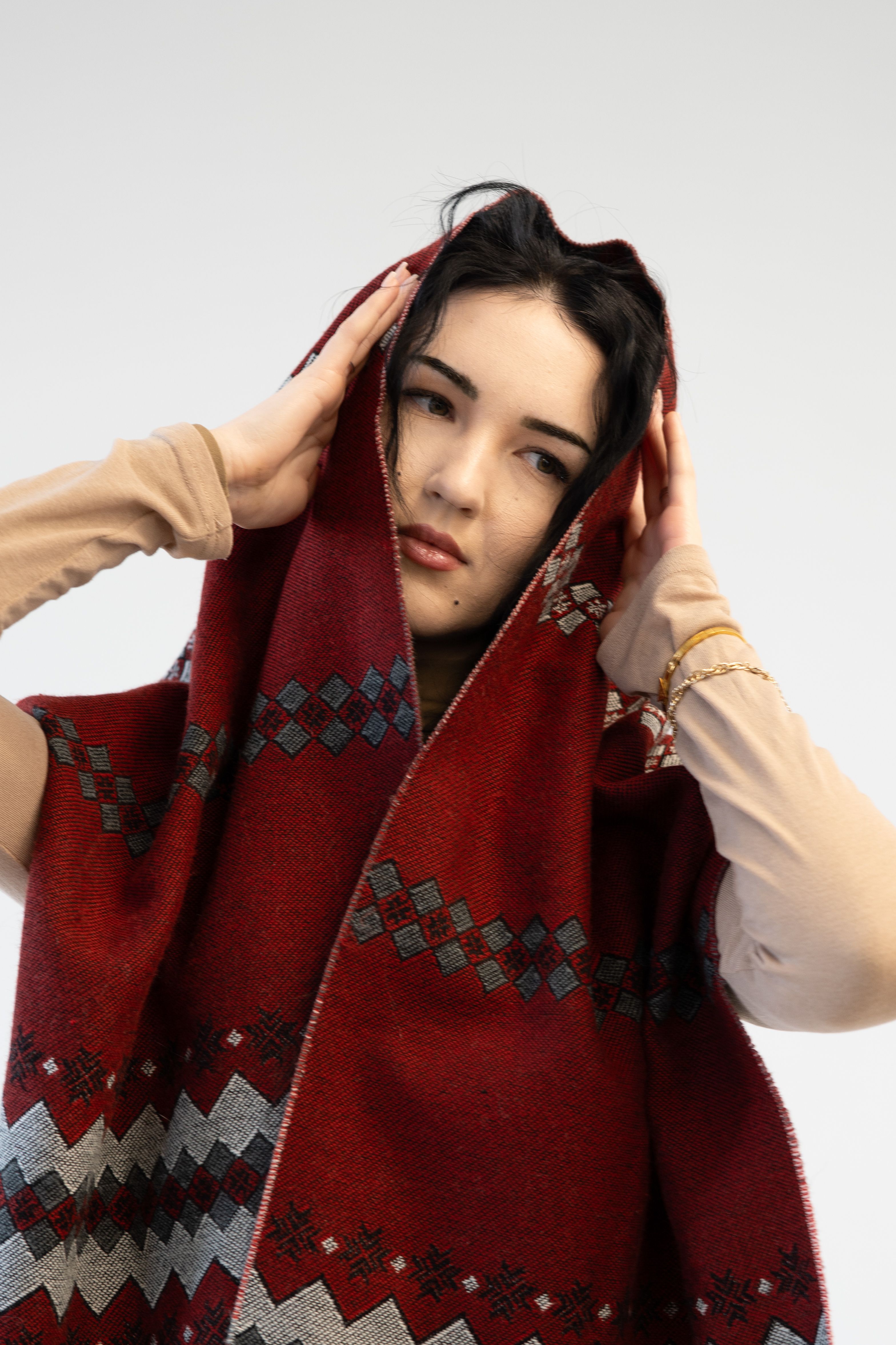 Gratuit Portret elegant al unei femei purtând un șal roșu cu model, cu o privire contemplativă. Fotografie de stoc