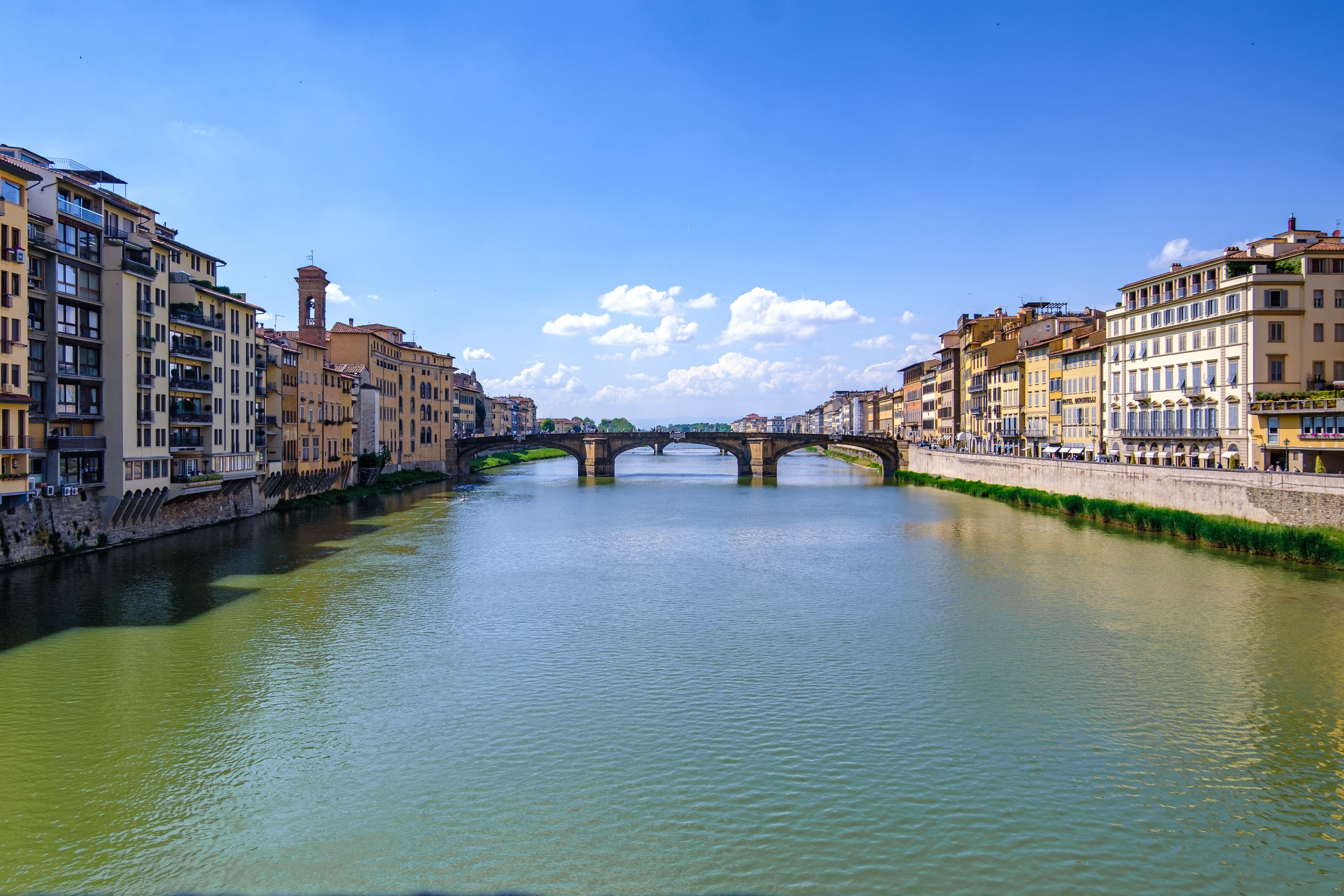 Gratuit O vedere pitorească a râului Arno cu clădiri istorice și poduri în Florența, Italia, sub un cer senin. Fotografie de stoc
