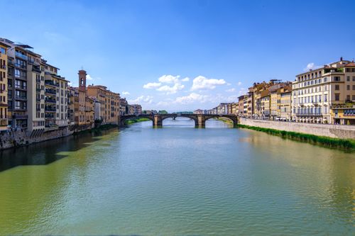 Gratuit O vedere pitorească a râului Arno cu clădiri istorice și poduri în Florența, Italia, sub un cer senin. Fotografie de stoc