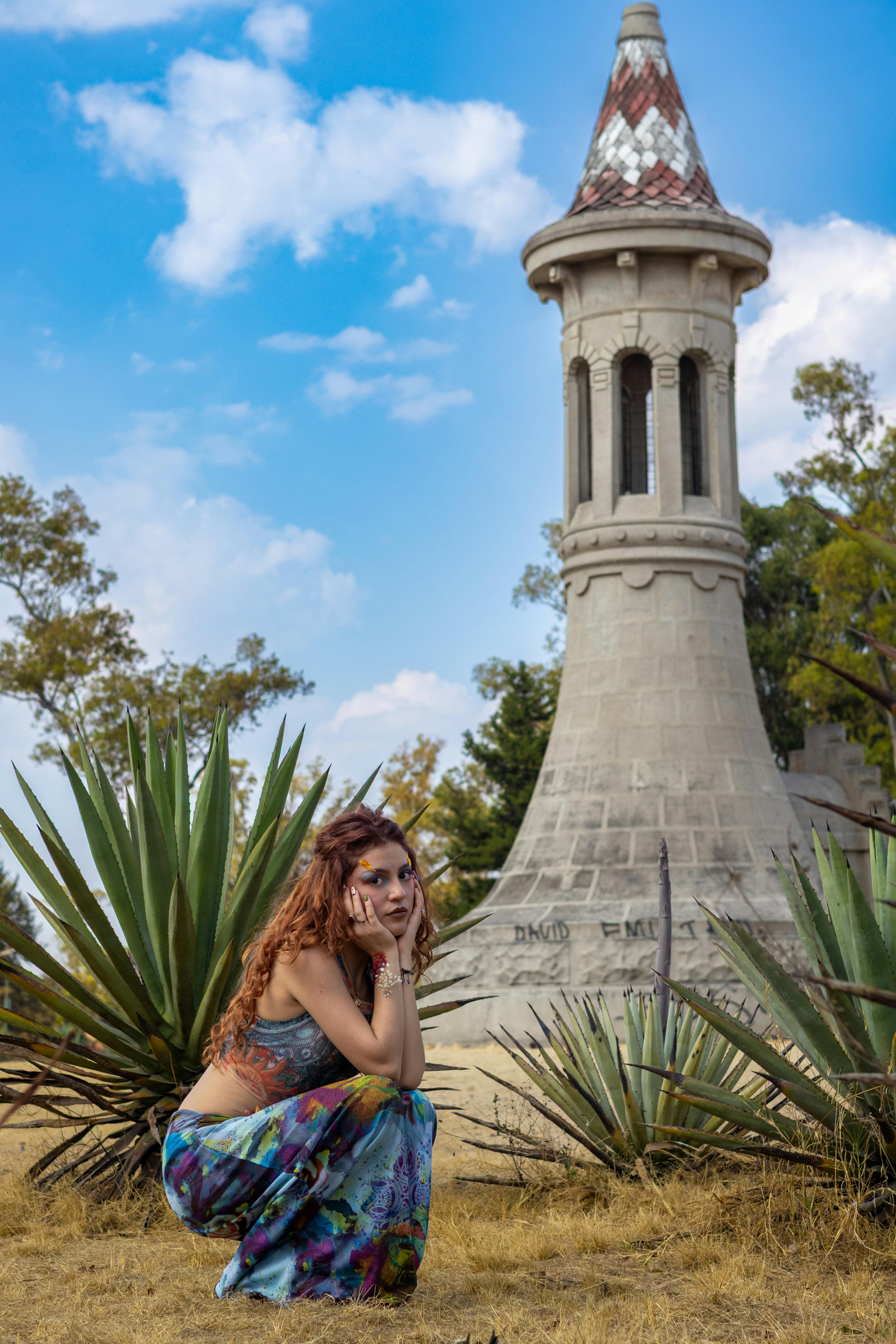 Zadarmo Žena pózuje vedľa ikonickej veže obklopenej agáve pod jasnou oblohou. Fotka z fotobanky