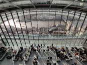 白天，现代中庭内的人们可以欣赏伦敦天际线和河流的景色