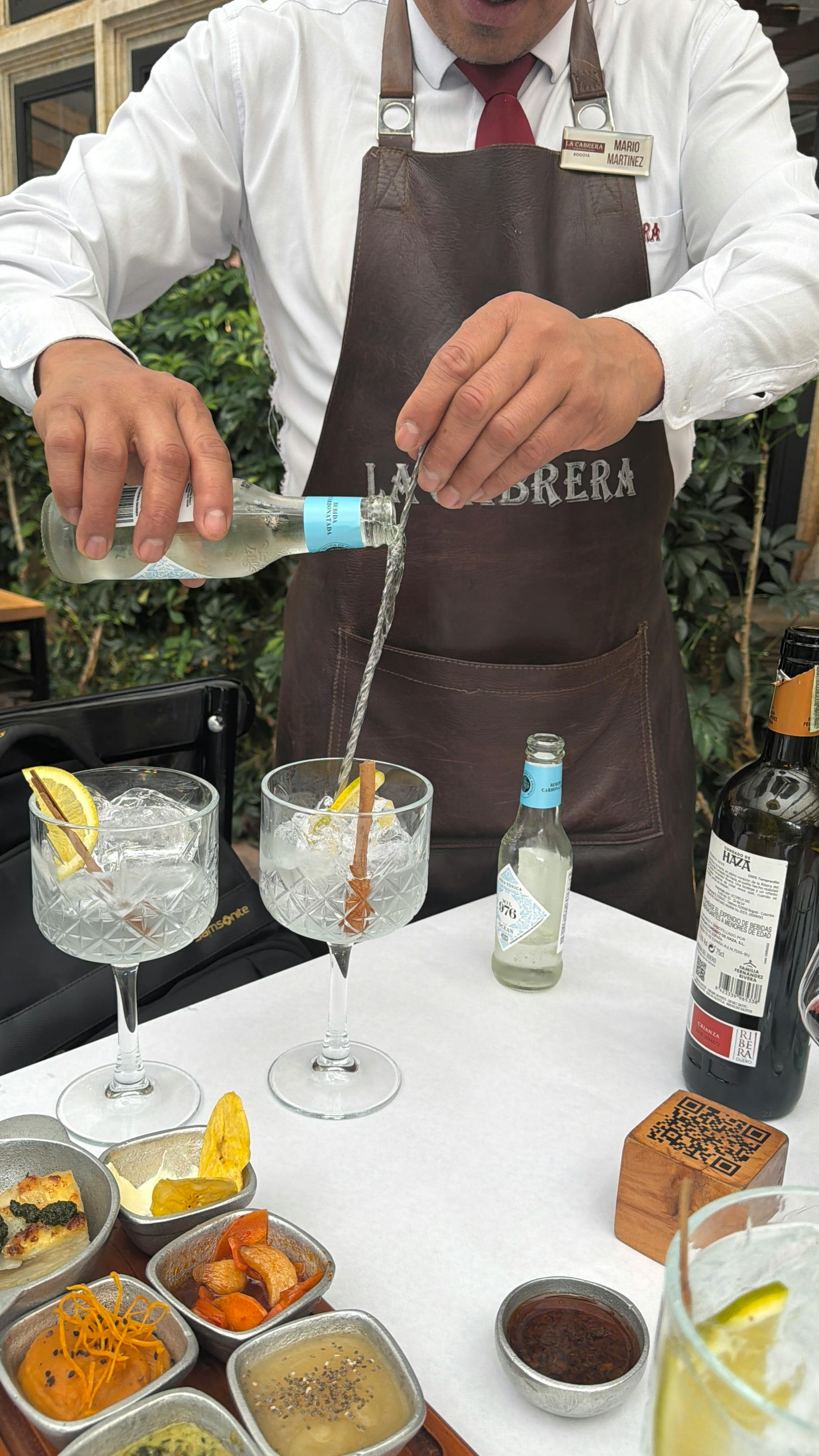 免費 在波哥大一家高檔餐廳，一位調酒師正在調製金湯力雞尾酒，並搭配各種開胃菜。 圖庫相片