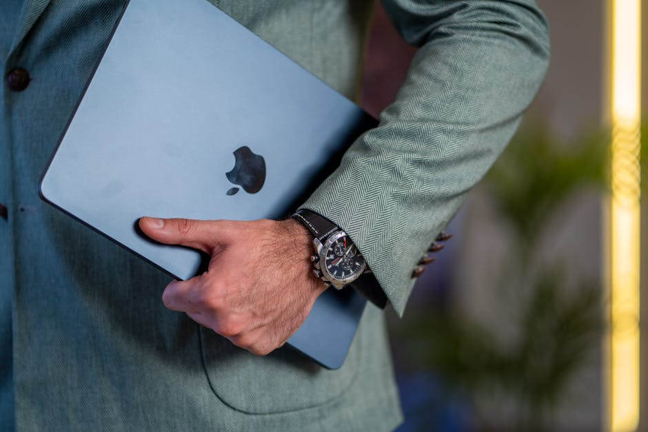Apple Watch vs Galaxy Watch: Workout Accuracy (2025) Close-up of a businessman holding a tablet in a stylish suit, showcasing elegance and modern technology.