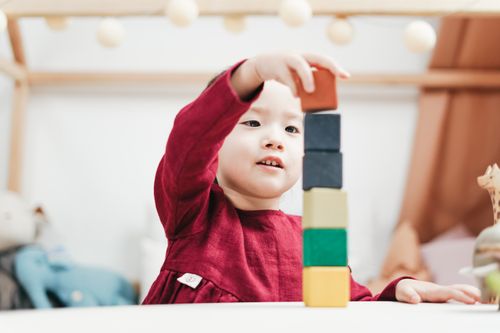 Young child playing with colourful wooden blocks