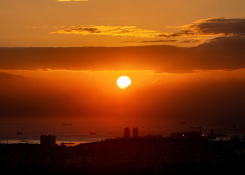 A breathtaking sunset over Manila Bay with ships silhouetted against the vibrant sky.