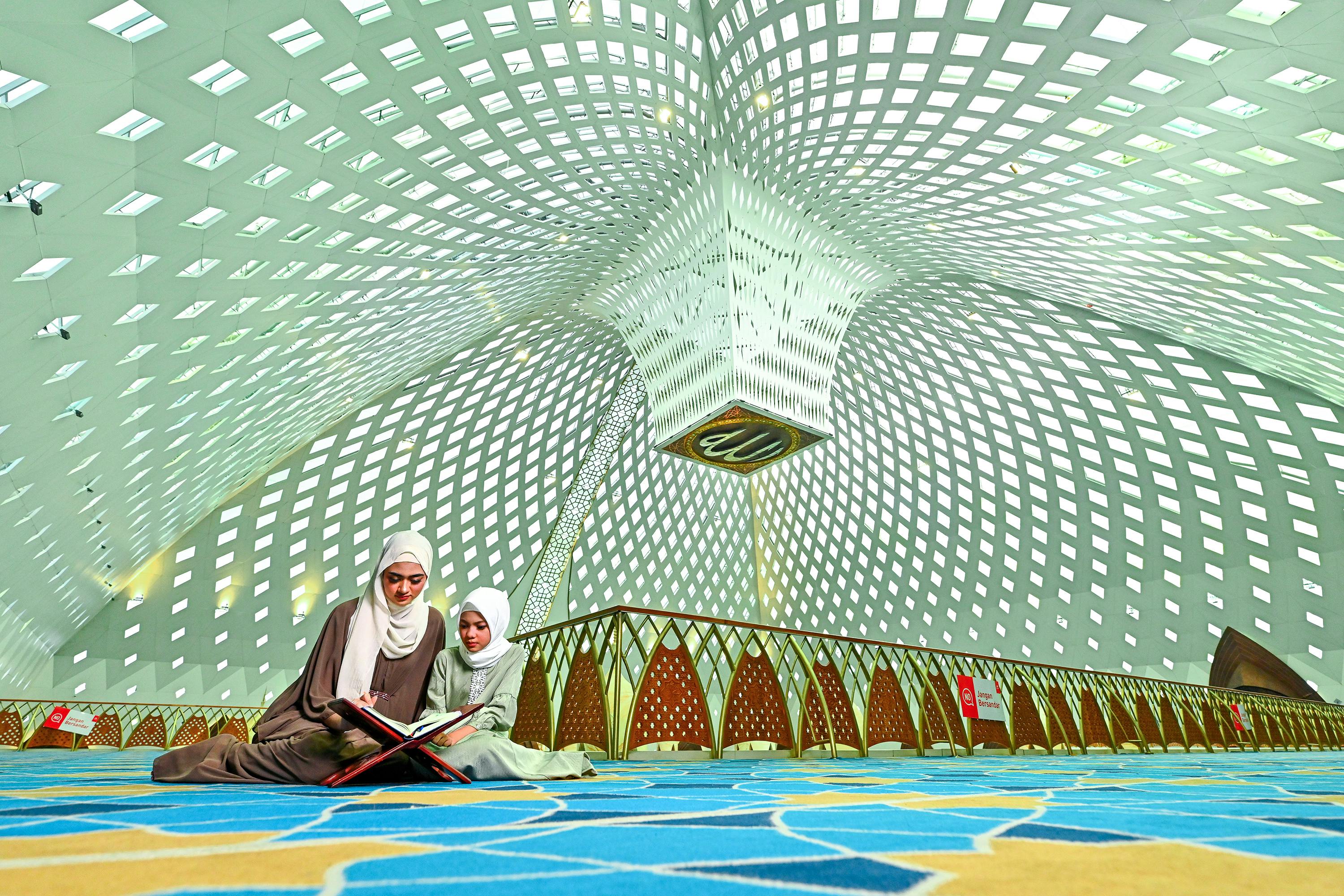 ingyenes Két nő Koránt olvas egy gyönyörűen megtervezett mecsetben Nyugat-Jáván, Indonéziában. Stockfotó